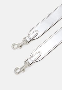 Cinturino in pelle argentata con finitura lucida, caratterizzato da cuciture precise e fibbie metalliche su entrambe le estremità.