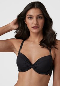 Černý bikiny top s uzlovým designem v přední části, nastavitelné ramínka s akcenty zlaté barvy a hladká, jemná textilní textura.