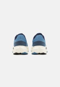 Scarpe da corsa blu con tomaia testurizzata, accenti blu navy e suola bianca spessa. Presenta il logo sul lato e il collare imbottito per il comfort.