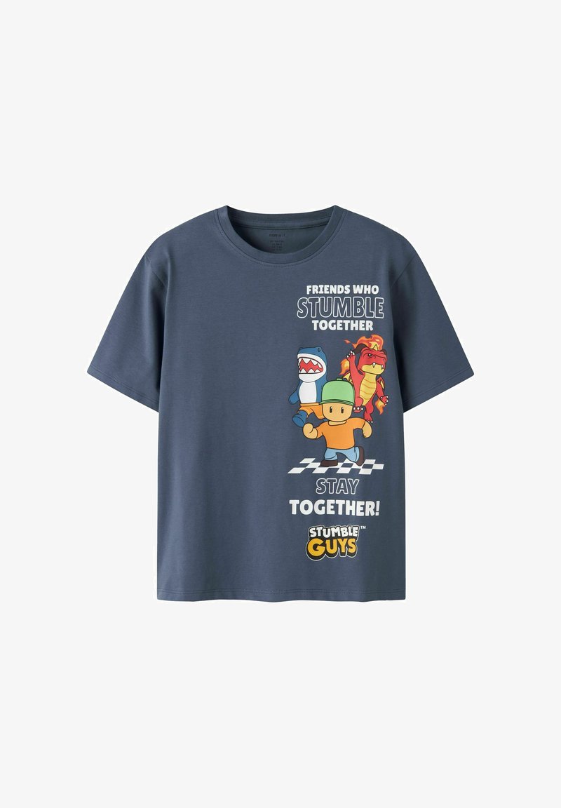 T-shirt bleu foncé avec des personnages de Stumble Guys et le texte « Les amis qui trébuchent ensemble restent ensemble » au-dessus d’une ligne d’arrivée à damier.