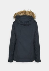 Svart jacka med fuskpälsfoder på huva, långa ärmar, en enkel design och en lätt utsvängd nederkant. Inkluderar en patch på ärmen.