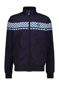 Giacca a vento blu navy con chiusura a zip, polsini a costine e una striscia checkered blu attraverso il petto. Logo sul lato sinistro.