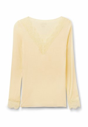 Krémová halenka s dlouhým rukávem, ozdobená krajkou na výstřihu do véčka a manžetách rukávů, jednoduchý a elegantní design.