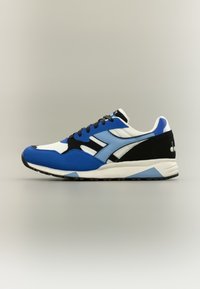 Μπλε και μαύρα αθλητικά παπούτσια με μίγμα δικτυωτού υφάσματος και σουέντ υλικών· διαθέτουν λευκό ενδιάμεσο πέλμα και χαρακτηριστικές μαύρες λεπτομέρειες.