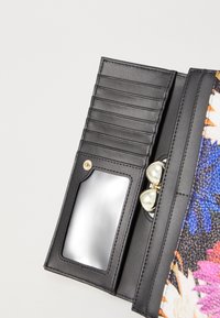 Mustan nahkalompakon sisäosa, jossa on useita korttipaikkoja, läpinäkyvä henkilökorttiikkuna ja pyöreitä helmi-sisustuksia; kukkakuosisella ulkopinnalla.