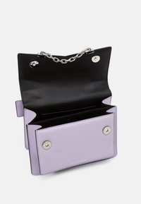 Fialová kožená kabelka s řetízkem, černým interiérem, dvěma přihrádkami a cvokovými uzávěry. Na přední straně je vyražené logo.