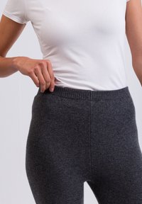 Grijze gebreide leggings met een geribbelde tailleband, gemaakt van zacht materiaal, met een gladde textuur en een aansluitende pasvorm.