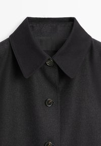 Black wool coat featuring a classic collar, two buttons, and a smooth texture. The design is simple and functional with no visible patterns.
