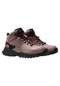 Botas de senderismo con una parte superior sintética rosa, acentos negros y una suela texturizada. Cuenta con cordones negros y un cuello acolchado para mayor soporte.