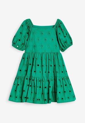 Vestido verde con mangas cortas abullonadas, escote cuadrado, falda de volantes y patrón de cortes circulares en toda la tela.