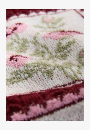 Úpletová látka s květinovými vzory v odstínech růžové a zelené, s texturovaným povrchem a bordó lemováním podél okraje.