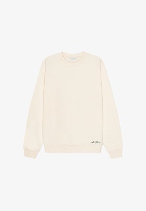 Sweatshirt couleur crème en matériau doux. Présente un col rond, des manches longues et un détail logo subtil à l'ourlet.