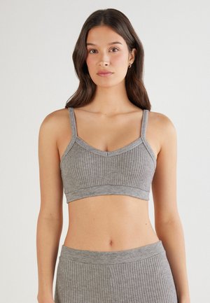 Bralette gris à côtes avec fines bretelles et décolleté en V. Fabriqué en matériau doux, avec un design sans coutures et une bande élastique en bas.