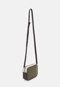 Piccola borsa a tracolla rettangolare con pannelli color verde oliva e crema, una base marrone scuro, cerniera dorata e tracolla regolabile.