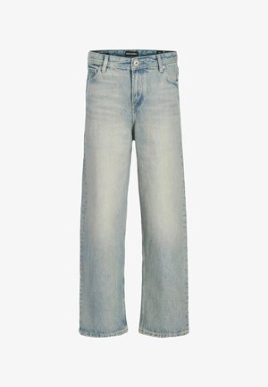 Jasno-beżowa kurtka z dwoma kieszeniami na piersi, zapinana na guziki, z prążkowanymi mankietami, w zestawieniu z jasnoniebieskimi dżinsami w luźnym kroju i białymi trampkami.