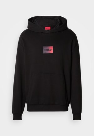 Črna kapuca iz mehkega materiala, z sprednjim kenguru žepom in pravokotnim logotipom v rdeči in črni barvi na prsih.