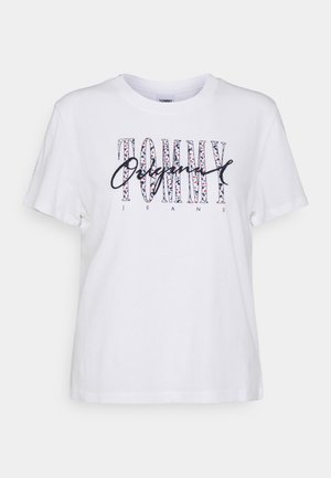 Witte t-shirt met korte mouwen met "TOMMY JEANS" in grote, patroond letters en het woord "Original" in schrijfletters op de borst.