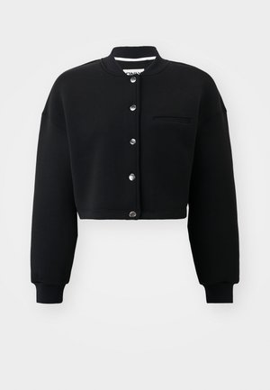 Czarna, krótka bluzka z okrągłym dekoltem, srebrnymi napami oraz kieszenią z przodu. Wykonana z miękkiego materiału z prążkowanymi mankietami.