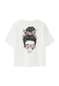 Vit t-shirt med en grafik av en tjej med knut, ett mönstrat hårband och hjärtformade glasögon, med texten "Love" nedan.