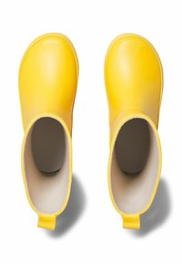 Bottes de cheville en caoutchouc jaune avec un extérieur lisse, un bout arrondi et une doublure beige douce. Chaque botte est dotée d'une languette à l'arrière pour un enfilage facile.