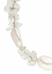 Halskette mit unregelmäßigen klaren Steinen und glänzenden weißen Perlenakzenten, die eine Mischung aus glatten und strukturierten Oberflächen präsentiert.
