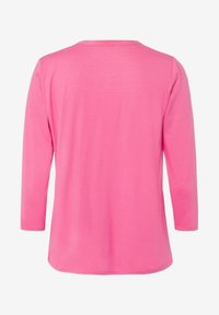 Camicia a maniche lunghe di un vivace colore rosa, realizzata in tessuto morbido. Presenta un collo rotondo e un orlo leggermente curvo.
