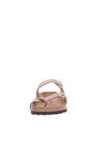 Pink leather sandals with two adjustable straps, cork footbed, and black rubber sole. Buckles and smooth texture are notable design features.