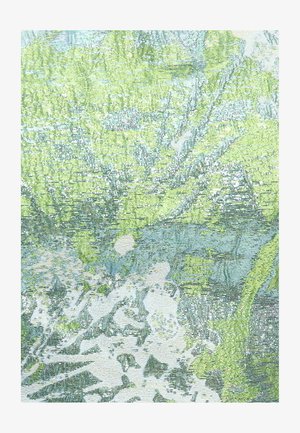 Gros plan sur un tissu avec des motifs floraux et feuillages complexes en vert, bleu et blanc, tissés dans un design texturé.