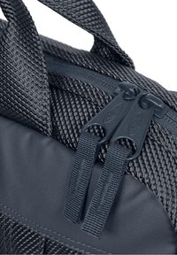 Sort tekstil rygsæk med et struktureret design, dobbelte lynlåse og holdbare stropper. Materialet ser robust ud med en mat finish.