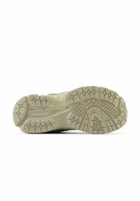 Light beige sneaker sole with a textured grip pattern, featuring hexagonal lugs and branding details, designed for traction and support.