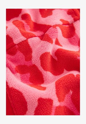 Fleece medžiaga su raudona ir rožine abstrakčia dėmėta, turinti minkštą tekstūrą ir nereguliaras formas, demonstruojanti ryškų spalvų kontrastą.