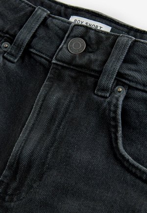Shorts en denim noir avec une fermeture à bouton et zip, avec un design classique à cinq poches et un tissu texturé. L'étiquette indique "BOX SHORT."