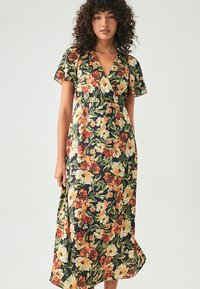 Gėlių rašto suknelė su trumpomis rankovėmis, V formos kaklu, juodu fonu ir oranžiniais, geltonais bei žaliais gėlių raštais. Pusilgis.