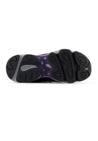 Μοκέτα αθλητικού παπουτσιού σε μωβ χρώμα με μαύρα ελαστικά στοιχεία· δι αθέτει εγκοπές και εμφανές λογότυπο "N" για πρόσφυση και στήριξη.