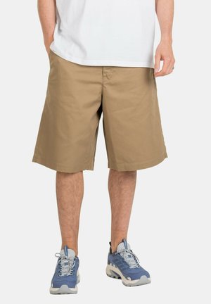 Beige cotton shorts with a relaxed fit, falling just above the knee, paired with blue athletic shoes.