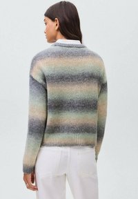 Pleteni pulover z gradientnimi črtami v sivi, zeleni in breskovi barvi. Rebrast rob in manšete, sproščen kroj, mehak otip in oblikovanje z V-izrezom.
