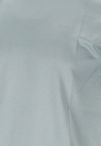 Vala sininen urheilusede, jossa on sileä rakenne ja hienovarainen heather-kuvio. Varustettu brodeeratulla "ENDURANCE"-tekstillä vaaleassa sävyssä.