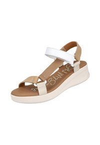 Sandalia sintética en tonos beige y blanca con dos correas ajustables, una suela acolchada y un ligero tacón. Presenta una plantilla beige con logotipo impreso.