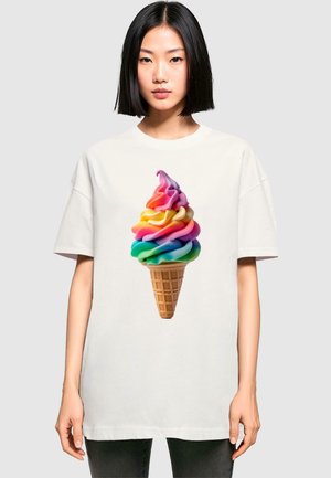Hvit oversized t-skjorte med et fargerikt design av mykservis-is med vaffelkule, som viser snurr av rosa, gul, blå og grønn.