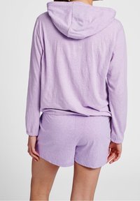 Hellblaues Loungewear-Set bestehend aus einem langärmligen Kapuzenoberteil und passenden Shorts. Der Stoff ist weich und hat eine strukturierte Oberfläche.