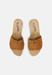 Tan suède sandalen met een kruislings ontwerp, met een houten inlegzool. Gladde textuur met stiksel langs de randen.
