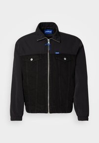 Giacca nera con zip, due tasche sul petto e etichette blu "HUGO" sul colletto e sul petto, polsini elastici e design in tessuti misti.