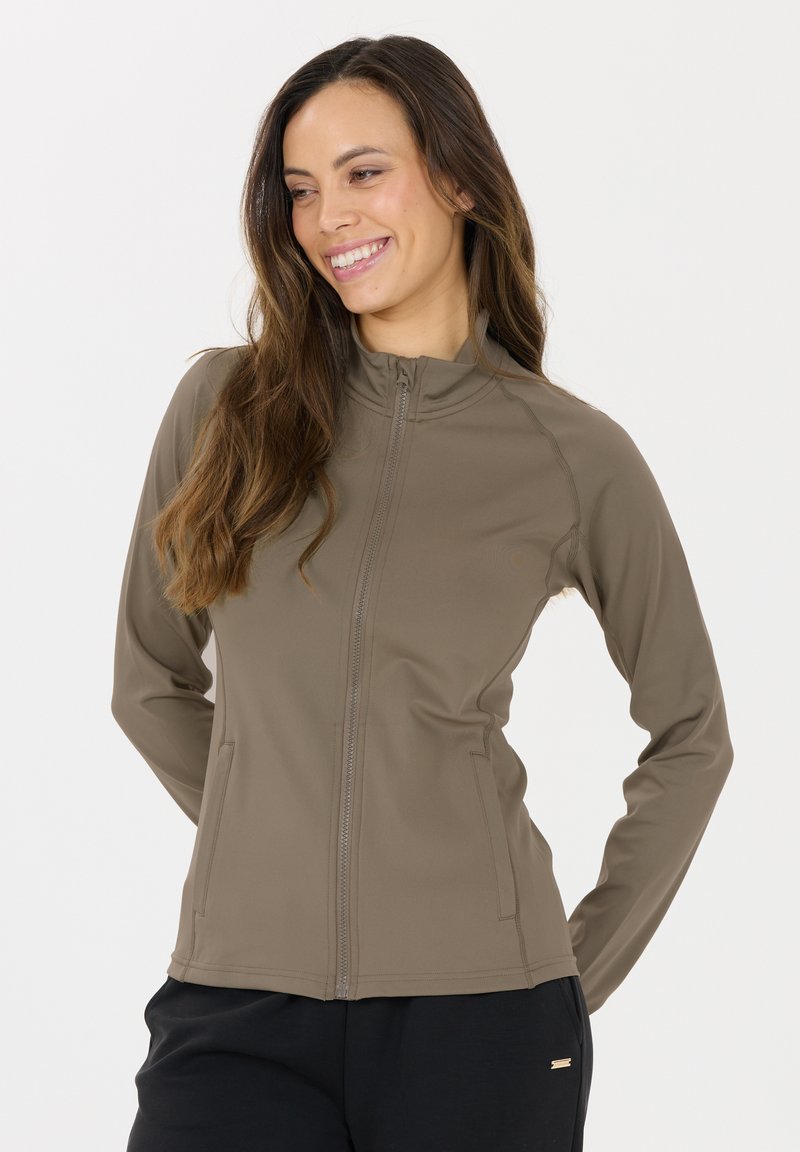 Braune Zip-Jacke aus glattem, dehnbarem Material mit hohem Kragen und Seitentaschen. Taillierte Passform mit subtilen Nahtdetails.