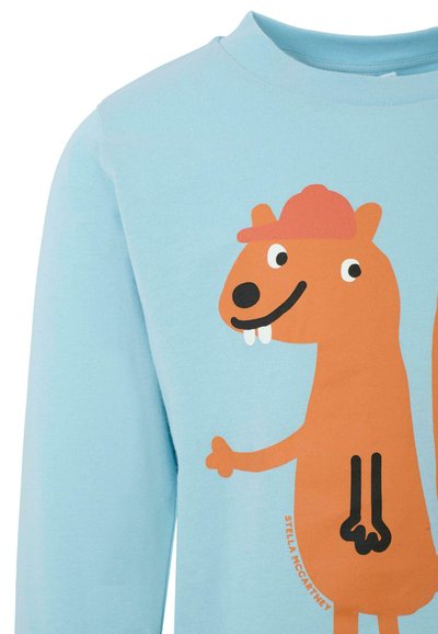 Sweatshirt en coton bleu clair avec un graphique de cartoon d'un écureuil orange portant un chapeau rose, souriant et montrant ses dents. Encolure arrondie.