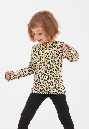 Langærmet, lynlåspullover i lys gul med sorte og orange leopardpletter, der har sorte og hvide stribede manchetter og kant.