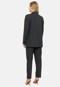 Schiefergrauer maßgeschneiderter Blazer und passende Hose, mit geradem Schnitt, glatter Textur und dezenten Nähten.