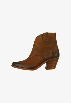 Hnedá kožená členková topánka s špicatou špičkou, dekoratívnym prešívaním a krátkym kontúrovaným podpätkom. Bočný jazýček pre ľahké obúvanie, jemný detail loga.