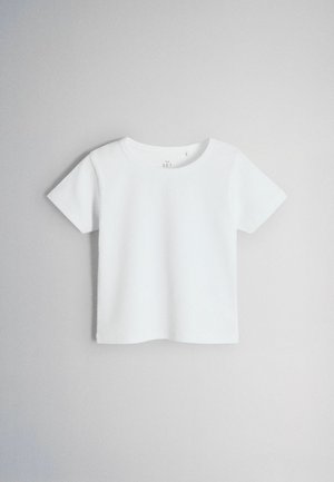 Tricou alb cu mânecă scurtă, cu tivuri și decolteu rotund, atârnând pe un fundal simplu, gri deschis.