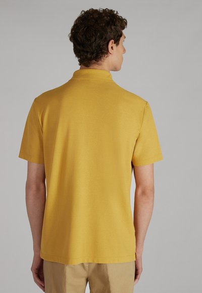 Żółta koszulka polo z krótkim rękawem o klasycznym kołnierzyku, wykonana z gładkiego materiału, z prostym dołem i subtelnymi detalami wyszycia.