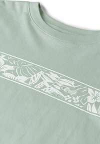 Hellgrünes T-Shirt aus Baumwolle mit weißem Blumenmuster auf der Brust, das Blätter-Motive und ein Logo zeigt. Rundhalsausschnitt, kurze Ärmel.